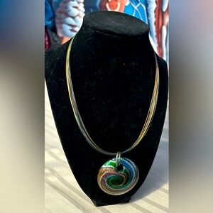 A 14 metal strand artisan piece with matching glass pendant. About a 16” length